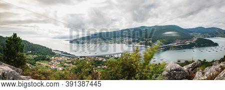 Panorama View Of The Ria De Vigo Estuary From Redondela On A Cloudy Summer Afternoon, With The Recen
