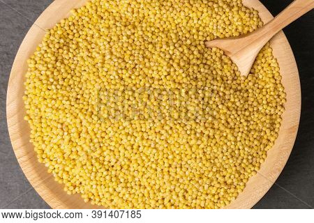 Raw Millet Grits In A Wooden Bowl On A Rustic Style. Selective Focus Dry Millet Groats