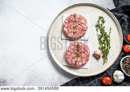 Raw Pork Patty, Ground Meat Cutlets On A Cutting Board. Organic Mince. Gray Background. Top View. Co