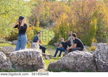 Split Croatia October 2020 A Group Of Friends Sitting Around On Rocks And Having Fun Talking And Rel