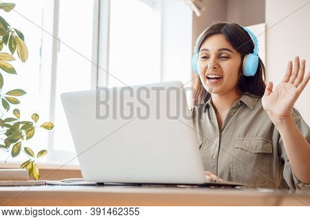 Happy Indian Woman Student Wear Headphones Waving Hand, Talking, Making Video Conference Call. Remot