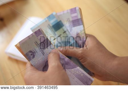 Close Up Of Woman Hand Counting Money Uang Indonesian Rupiah And Making Notes, Money Financial Manag