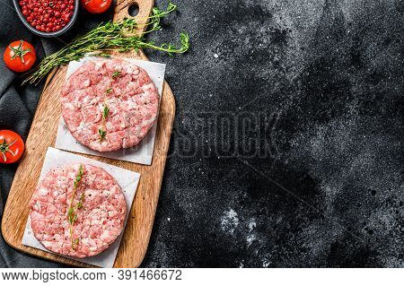 Raw Pork Cutlets, Ground Meat Patty On A Cutting Board. Organic Mince. Black Background. Top View. C