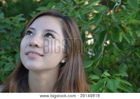 Beautiful young asian woman thinking in the park