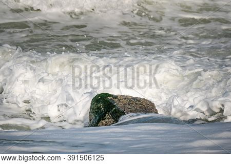 Rock In The Surf With Breaking Waves All Around It. North Sea Coast, Westkapelle, The Netherlands