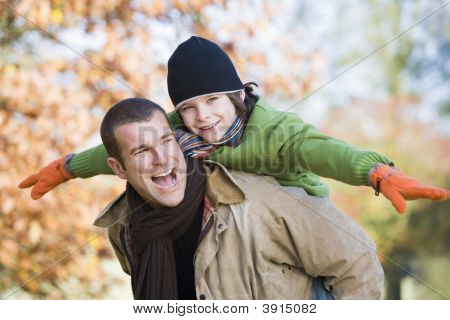 Uomo con bambino sulla schiena In Woodland