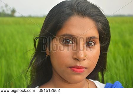Close Up Of Teenage Girl Wearing Golden Nose Pin And Ear Rings With White Cotton Salwar Kameez Stand
