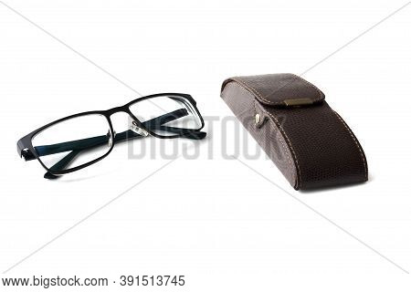 Stylish Hard Case Made Of Genuine Brown Leather. Dioptrics Black Eyeglasses Lie Next To The Case