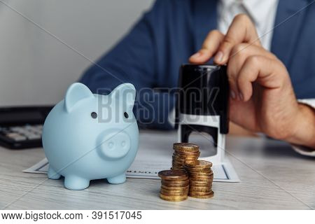 Blue Piggy Bank With Stack Of Coins On Desk In Office. Save Money And Management Financial Concept