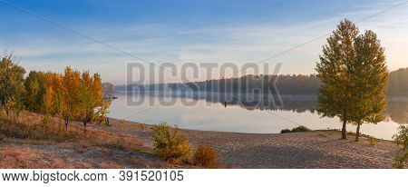 Section Of The Wide Navigable River With Sandy Bank And Trees With Autumn Leaves On A Foreground, Fo
