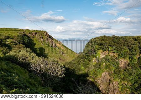 Scottish Landscape With Hills And Gorge Near Staffin At Isle Of Skye With Green Pastures At Sunset