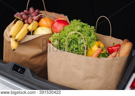 Groceries From A Supermarket In A Car Trunk. Food Delivery During Quarantine. Cruft Paper Eco Bags F