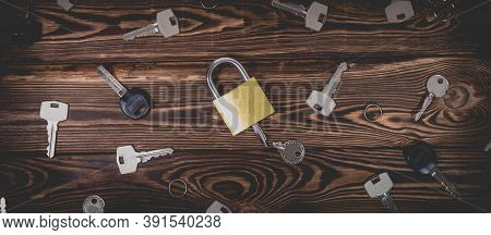Studio Photo Of A Lock With A Broken Key In It On A Wooden Background. Lots Of Other New Keys Around