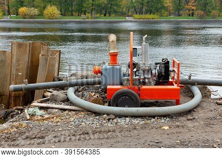 Diesel Motor Pump For Pumping Water On The River Bank. Construction Works To Strengthen The Banks Us