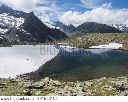 Beautiful Glacial Lake With Springs From Melting Ice Glacier With Sharp Snow-capped Mountain Peaks R