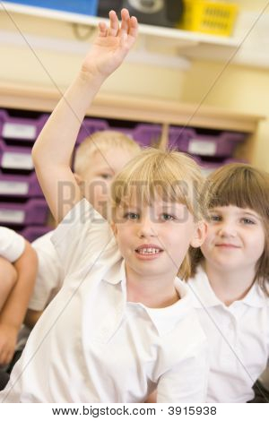 Portrait Of Child Sitting On Carpet In Classroom