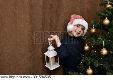The Child Cheerfully Imagines In His Hand Near The Christmas Tree.