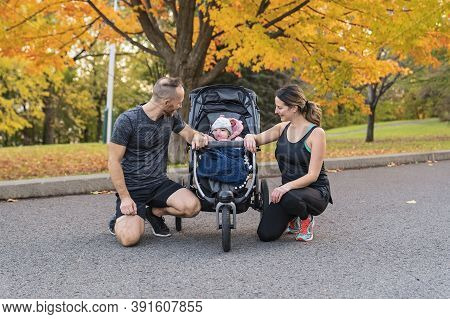 A Jogging Couple With Stoller On Autumn Season