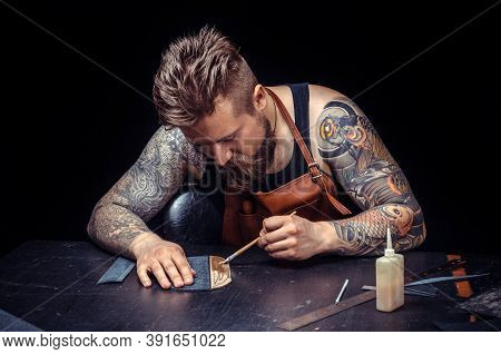 Craftsman Working With Leather Cuts Out Leather Goods In The Tanner Shop