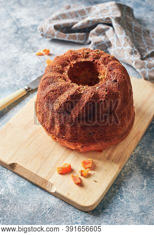 Homemade Autumn Carrot Cake With Candied Fruits On Wooden Cutting Board On Blue Background