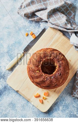 Homemade Autumn Carrot Cake With Candied Fruits On Wooden Cutting Board On Blue Background