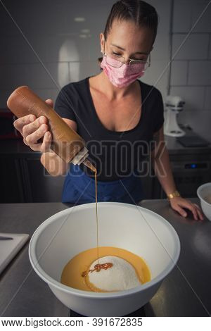 Young woman with mask makes a non-industrial homemade cake