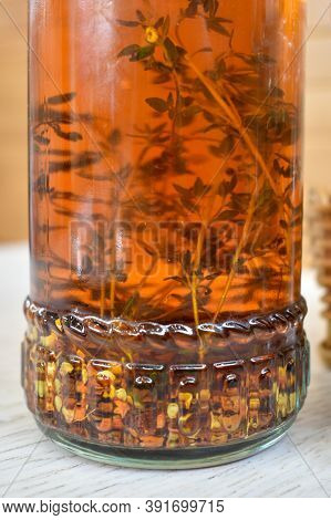 Glass Bottle Filled With Spicy Olive Oil With Chili And Rosemary, Close-up. Fragrant Oil For Pizza, 