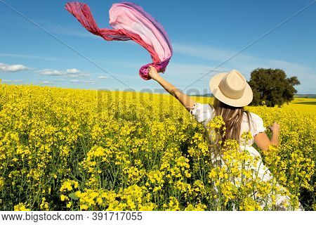Woman In White Sun Dress In A Field Of Flowering Golden Canola