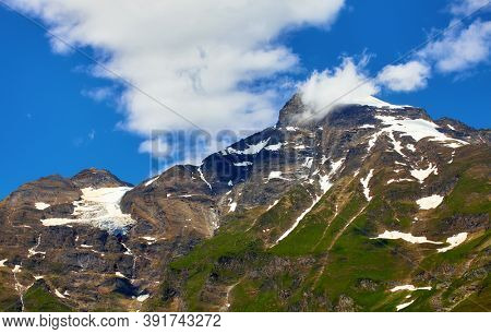 Panoramic view at Pasterze Glacier Grossglockner among Austrian Alps mountains and blue sky clouds.