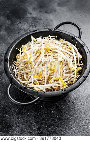 Sprouts Of Sprouted Beans In A Colander. Vegetarian Food. Black Background. Top View