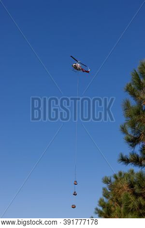 Prospect,  Oregon / Usa - September 9, 2014:  A Supply Helicopter Carrying Three Parcels Comes In Fo
