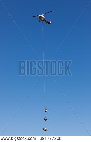 Prospect,  Oregon / Usa - September 9, 2014:  A Supply Helicopter Carrying Three Parcels Comes In Fo