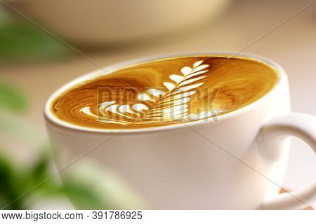 Latte Art Coffee In White Mug With White Background And Green Leaves