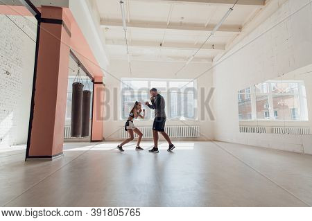 In A Spacious Loft, A Male Trainer And His Female Mentee Conduct A Boxing Training Session