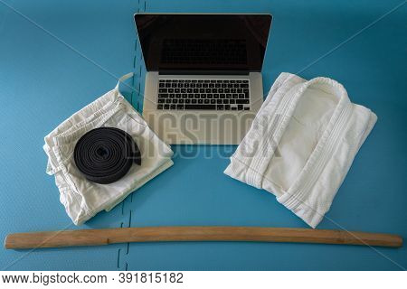 Martial Art Aikido Uniform On A Tatami With Notebook For On Line Training And Boken.
