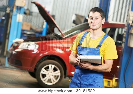 meccanico auto riparatore con appunti davanti all'auto moderne durante la manutenzione dell'automobile a engin