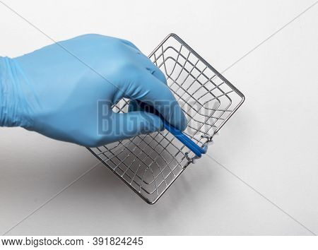 Shopping Metal Empty Basket In Male Hand In Blue Protecive Glove. Shopping During Coronavirus Lockdo