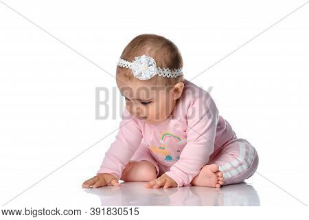 Little Baby Examines His Reflection On The White Floor In The Studio Against The White Wall. Child D