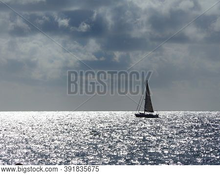 Barcelona Skyline And Sailingboat In Mediterranean Sea