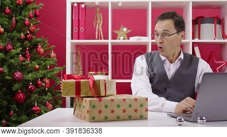 Cheerful Happy 40s Corporate Employee Ordering Gifts Online. Gift Boxes Fall On Table At Christmas D