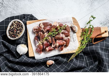 Raw Chicken Hearts On A Cutting Board. Organic Offal. White Background. Top View