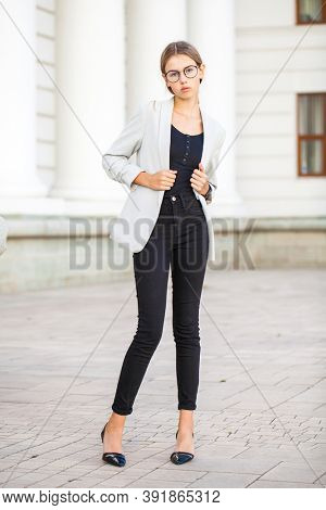 Full length portrait of a young beautiful girl in a business jacket