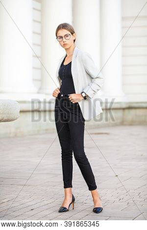 Full length portrait of a young beautiful girl in a business jacket