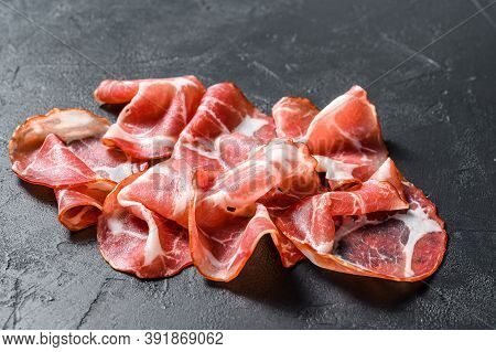 Italian Rolled Bacon Pancetta Piacentina. Pork Meat. Black Background. Top View