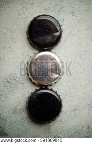 Collection of bottle caps on a stone table.