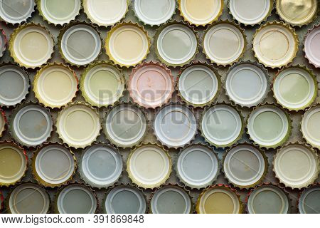 Collection of bottle caps on a stone table.