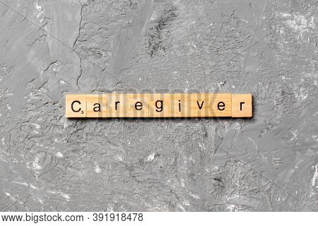 Caregiver Word Written On Wood Block. Caregiver Text On Table, Concept