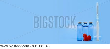Glass Medical Ampoules, Syringe And Red Heart On A Light Blue Background. Healthcare Concept: Saving