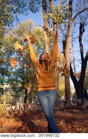 Beautiful Caucasian Young Woman Walking And Having Fun Outdoors In Autumn Time. Bright Yeallow Color