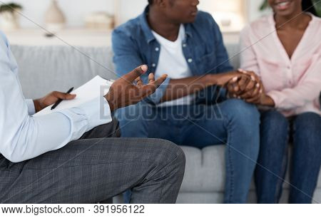 Happy Reconciling. Unrecognizable Black Couple Holding Hands During Therapy Meeting In Counselors Of